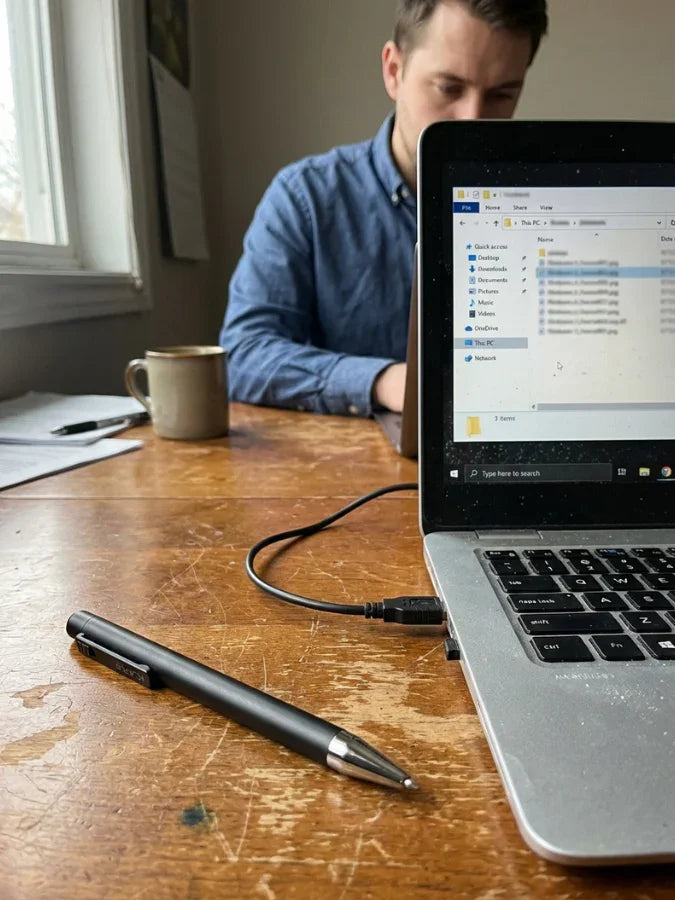Smart AI note-taking pen on a desk near laptop, ideal for meetings and digital notes